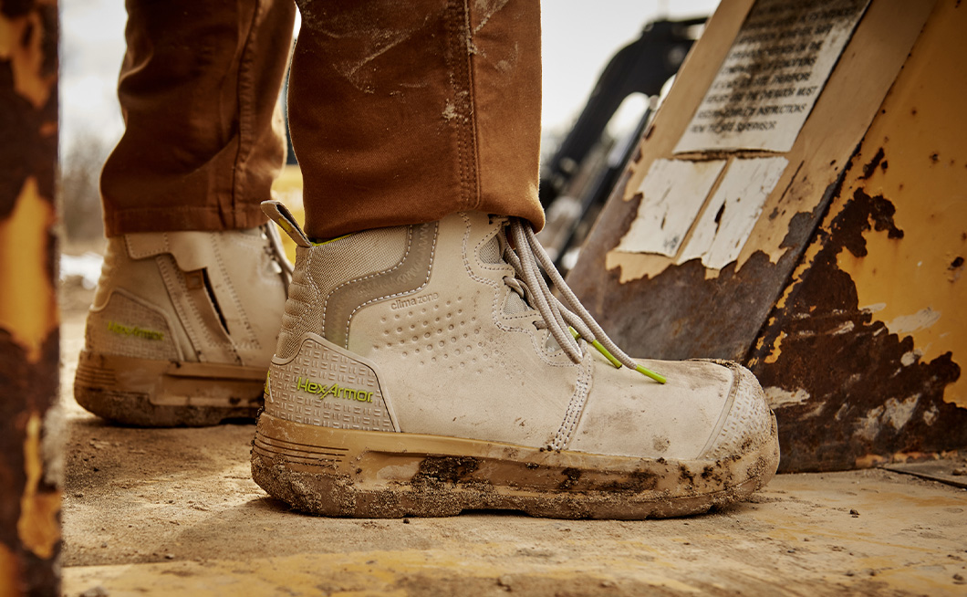 Pair of Xtend women's work boots with composite safety toe on a female construction worker.